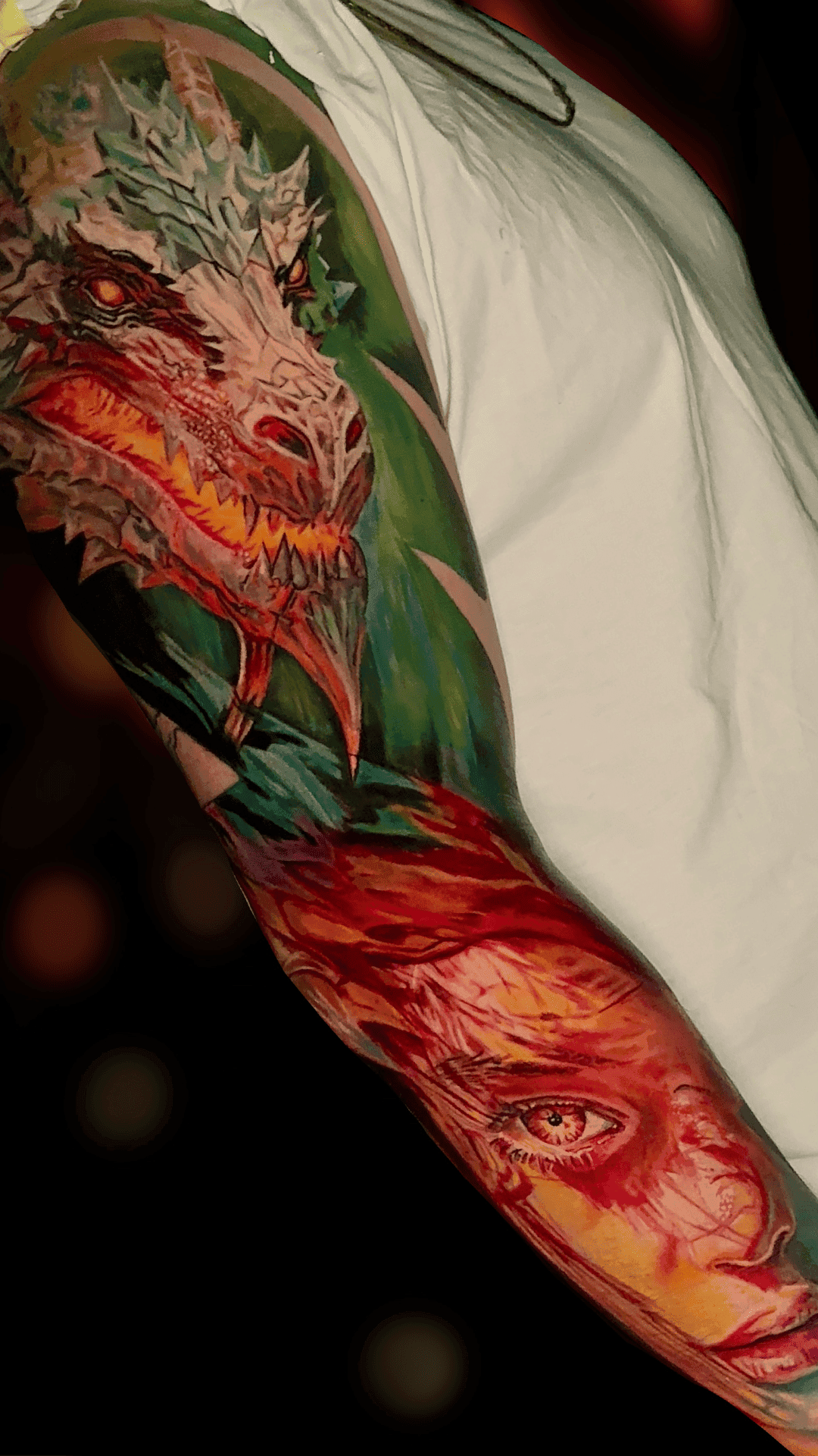 Color realism sleeve with a dragon on the shoulder and a woman's face on the forearm