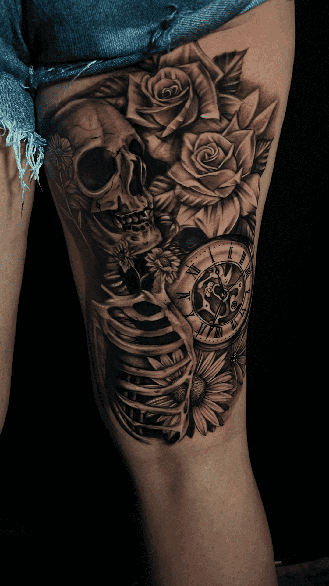 Black-and-grey tattoo combining a skull, roses and a clock