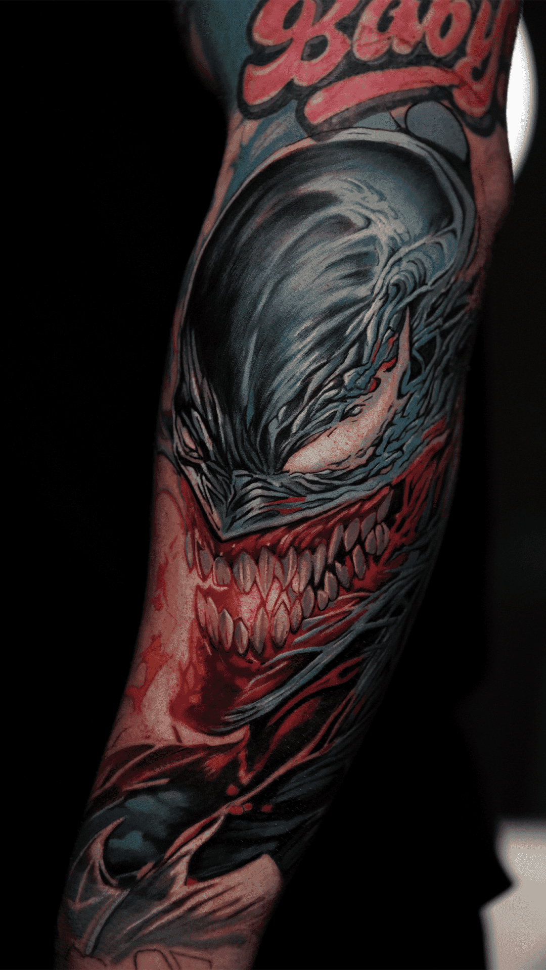 Color realism tattoo of the comic-book character Venom on an arm